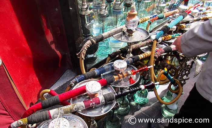 Traditional Turkish shisha pipes displayed outside a historic cafe on a cobblestone street in Sultanahmet, Istanbul.