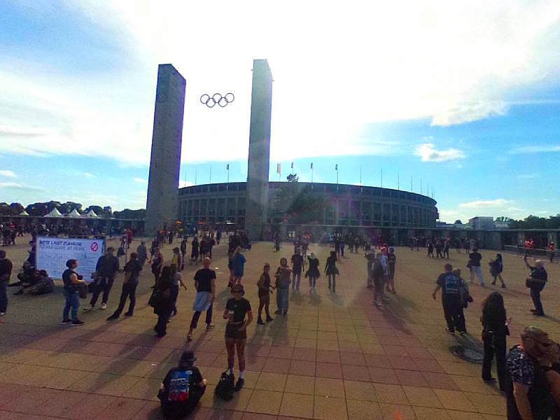 Fans gathering outside the Berlin Olympiastadion beneath the iconic Olympic rings during a System of a Down concert event.